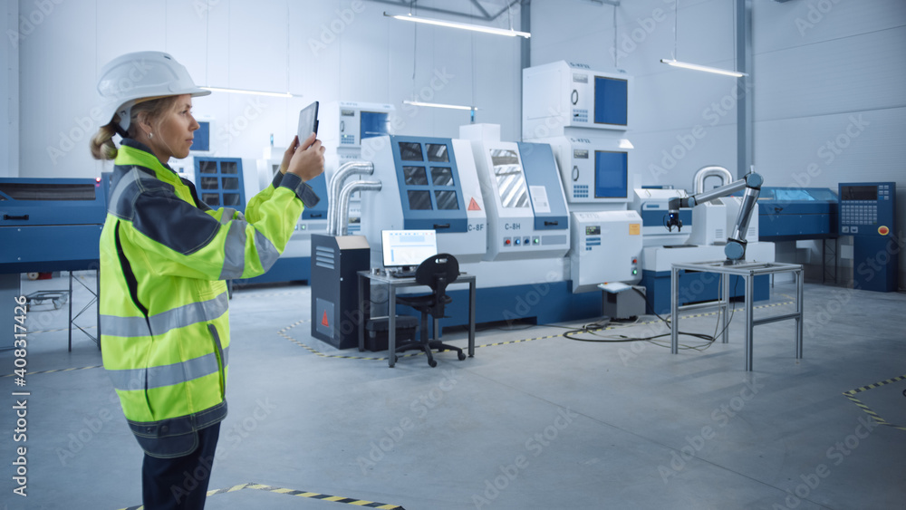 Poster Industry 4.0 Modern Factory: Female Engineer Uses Digital Tablet Computer with Augmented Reality to Visualize Workshop Mapping, Floor Layout. Facility with High-Tech CNC Machinery and robot arm
