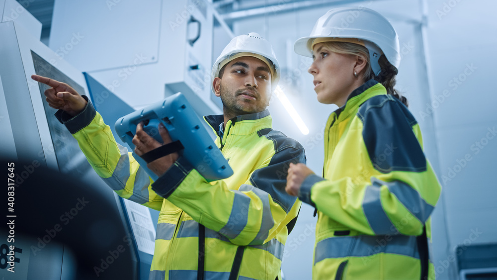 Aufkleber Chief Engineer and Project Manager Wearing Safety Vests and Hard Hats, Use Digital Tablet Controller in Modern Factory, Talking, Programming Machine For Productivity. Low Angle Portraits