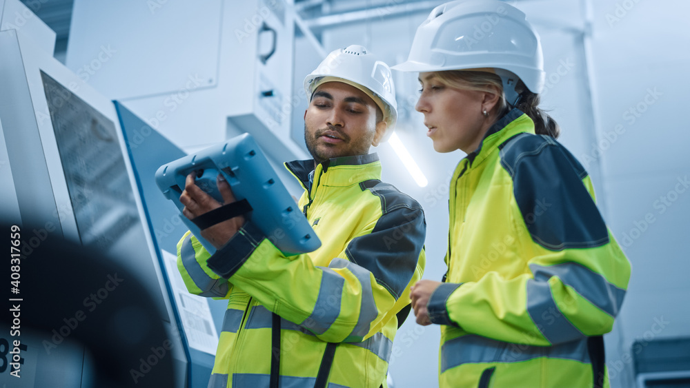 Poster Chief Engineer and Project Manager Wearing Safety Vests and Hard Hats, Use Digital Tablet Controller in Modern Factory, Talking, Programming Machine For Productivity. Low Angle Portraits