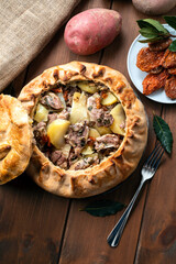 Panada Sarda, pietanza tipica della Sardegna a base di pasta cotta al forno e ripiena di agnello,...