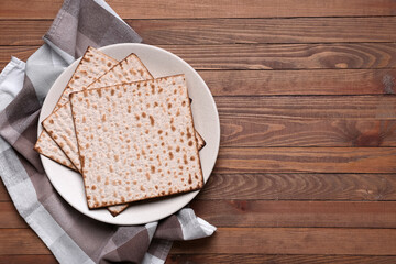 Plate with Jewish flatbread matza for Passover on wooden background