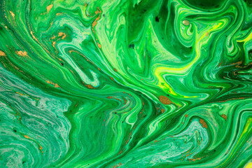 Green and yellow marble abstract acrylic background. Marbling artwork texture. Agate ripple pattern. Gold powder.