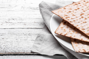Plate with Jewish flatbread matza for Passover on wooden background, closeup