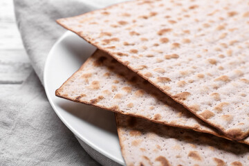 Plate with Jewish flatbread matza for Passover on wooden background, closeup
