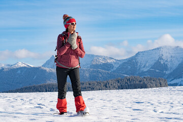 nice active senior woman snowshoeing in the Allgaeu Alps near Oberstaufen with view on the...