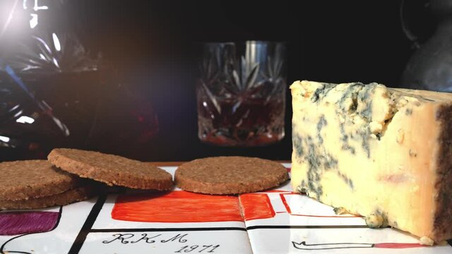 Oatcakes with a wedge  of cheese and whisky in the background - slide right