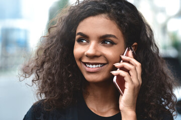 Positive emotions. Lifestyle concept. Close up of young mixed race woman use a phone.