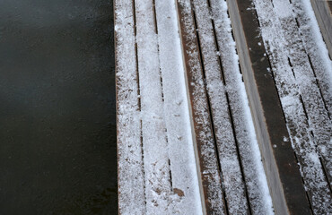 wooden seating with benches lined with natural wood in the woods by the water. everything is wooden...