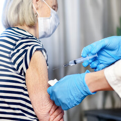 85-year-old woman receives the covid-19 vaccine from a doctor at home. Vaccination of the elderly.