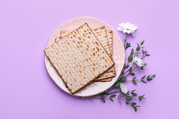 Plate with Jewish flatbread matza for Passover and flowers on color background