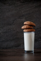 glass of milk and oatmeal cookies on a wooden table