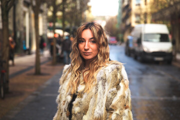 Obraz premium Portrait of a young caucasian blonde woman on the street with a big coat