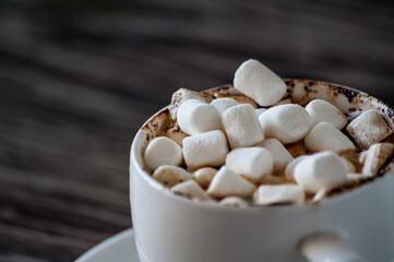 cup of coffee with marshmallows on a wooden table