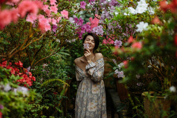 Obraz na płótnie Canvas happy girl in greenhouse with azaleas
