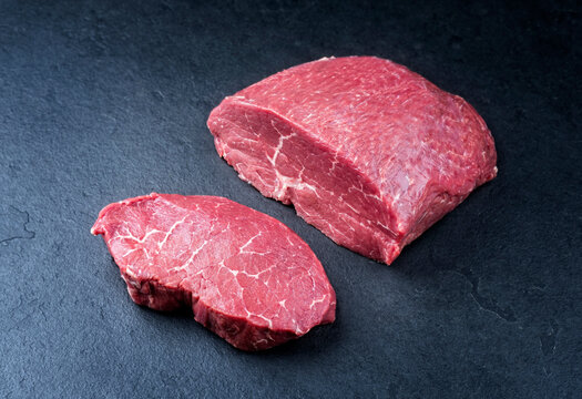 Rohes dry aged Wagyu Steak von der Rinderh&uuml;fte aufgeschnitten und am St&uuml;ck als close-up auf schwarzen Hintergrund mit Textfreiraum