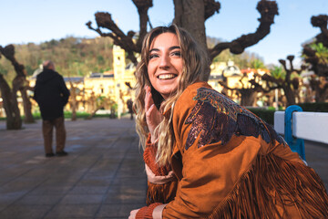 Portrait of a young caucasian woman sat on a bench at Donostia-San Sebastian downtown; Basque Country.