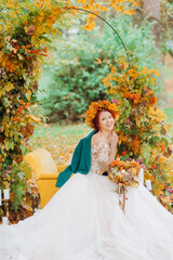 Obraz na płótnie Canvas Red-haired bride in a beautiful wreath, autumn wedding in the style of boho