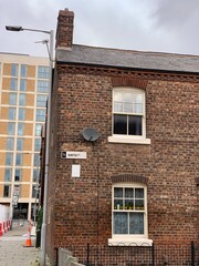 old brick house with a modern building in the background. Taken in Manchester England. 