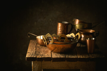 Vintage copper dishes, pots and pans on dark wooden background