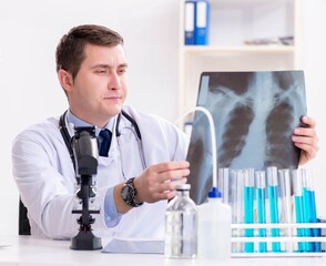 Male doctor looking at lab results in hospital