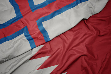 waving colorful flag of bahrain and national flag of faroe islands.