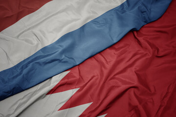 waving colorful flag of bahrain and national flag of luxembourg.