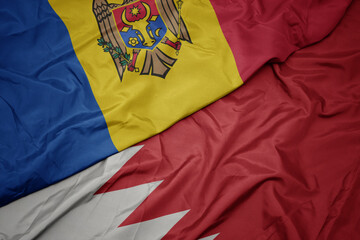 waving colorful flag of bahrain and national flag of moldova.