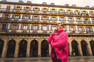 Young caucasian blonde woman talking by phone at the street