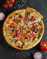 pizza with meat and vegetables on a dark background and with food styling