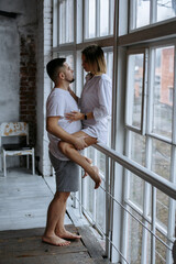 couple hugging on the background of a large window
