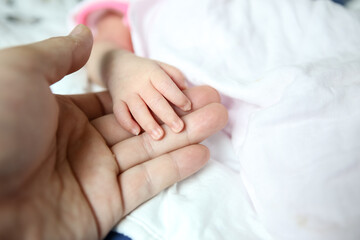 Fototapeta na wymiar Closeup of adorable newborn baby feet on white blanket in a selective focus, childhood concept - Image