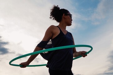 Woman playing with dance hoop in the afternoon