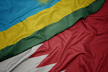 waving colorful flag of bahrain and national flag of rwanda.