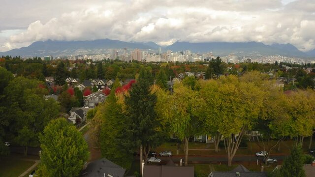 Aerial flying over a residential neighbourhood revealing the downtown Vancouver skyline.