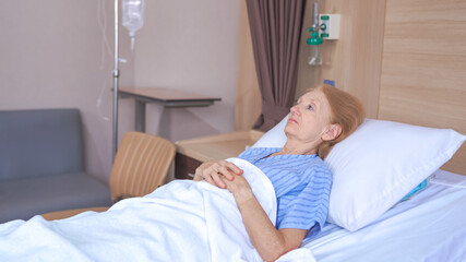 Lonely senior woman lying on bed