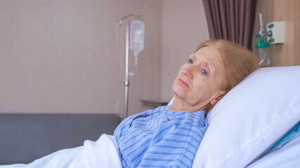 Lonely senior woman lying on bed