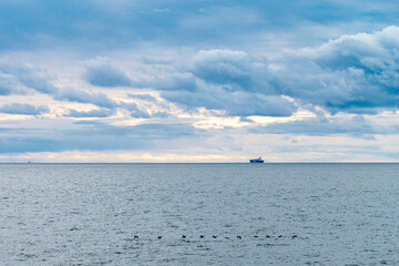 the ship sails on the sea against the backdrop of a beautiful cloudy sky.