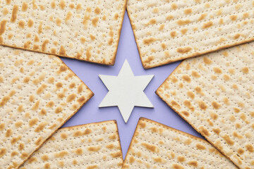 Jewish flatbread matza for Passover and Star of David on color background