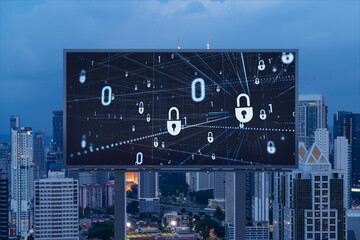 Padlock icon hologram on road billboard over panorama city view of Kuala Lumpur at night to protect business, Malaysia, Asia. The concept of information security shields.