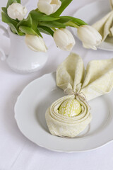Easter table styling with green painted and wax decorated Easter egg and white tulips