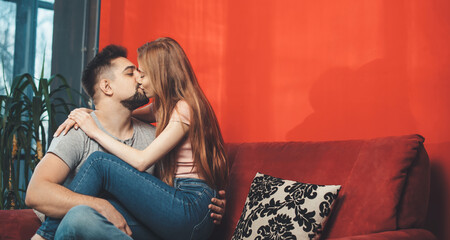 Caucasian man holding his ginger woman on legs and kissing her celebrating together the valentines day