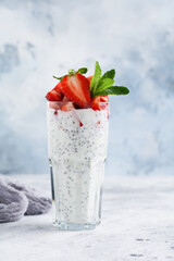 Vegetarian healthy smoothie strawberries, mint and chia seeds on gray concrete background. Selective focus. Space for text.