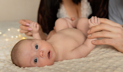 Adorable newborn 2 months or 6 weeks old baby close-up portrait. Baby holding mother's and father's...