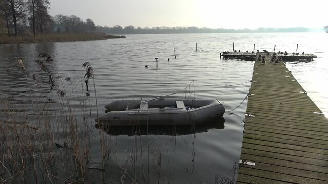 Dinghy inflatable boat in the water at a jetty in a northern German lake.