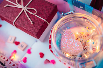 heart shape and light decorative in jar and them in box present. wooden letter block, feather, little gift box in present. Love, Valentine and holiday concept.