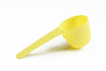 Empty measuring spoon isolated on white background. Deep yellow instrument