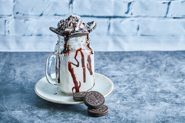 Oreo milkshake with sprinkling on the ceramic plate
