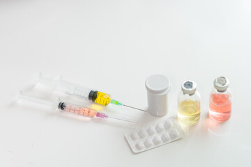 Medical equipments including vaccine, syringe, and pills on the table