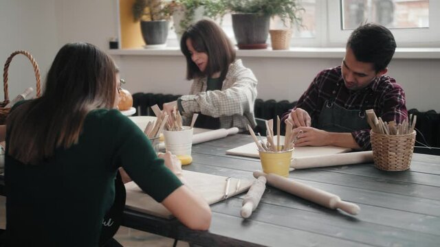 Potter masterclass, Man and woman are working with pottery wheel making pots during master class for adults, creative craftsman hobby. DIY Leisure activities and craftsmanship concept.