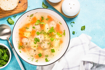Meatballs soup with vegetables. Traditional Ukrainian dish. Top view on light table.